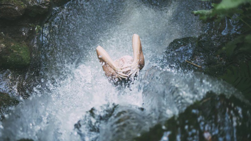 Rien que de l'eau... Femme sous une cascade d'eau fraiche